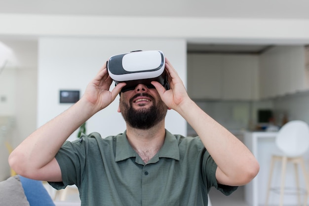 guapo hipster con barba probando gafas vr en casa moderna