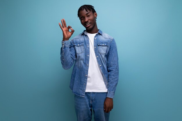 Guapo hombre americano con rizos afro en traje de mezclilla casual sobre fondo azul con espacio de copia