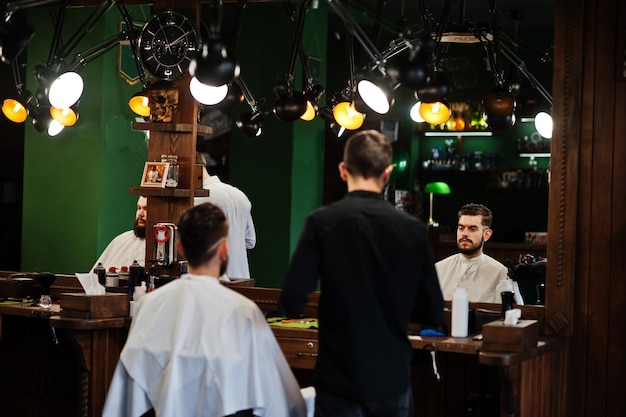 Guapo hombre barbudo en la barbería peluquero en el trabajo