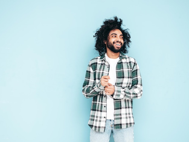 Guapo hombre hipster sonriente posando en el estudio