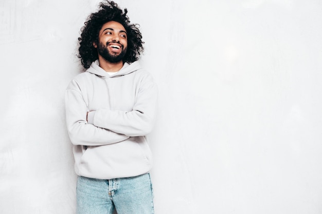 Guapo hombre hipster sonriente posando en el estudio