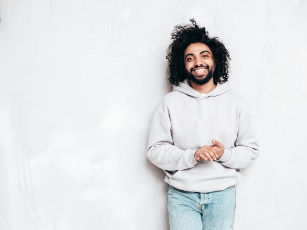 Guapo hombre hipster sonriente posando en el estudio