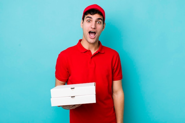 Guapo hombre hispano que parece muy conmocionado o sorprendido concepto de entrega de pizza
