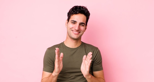 Guapo hombre hispano que se siente feliz y exitoso sonriendo y aplaudiendo diciendo felicitaciones con un aplauso