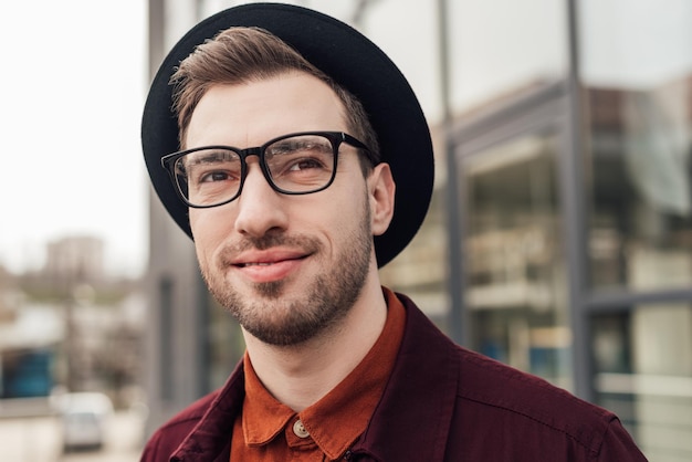 Guapo hombre de moda en anteojos y sombrero