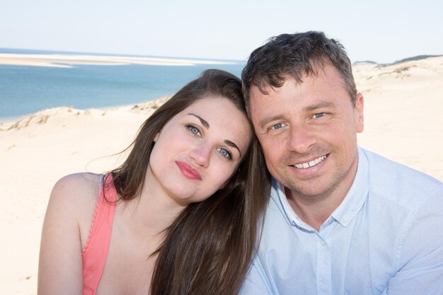 Guapo hombre y mujer sonriendo en la playa