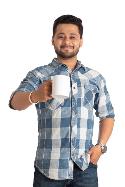 Guapo hombre sonriente con una taza de café o té aislado sobre fondo blanco.