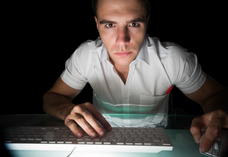 Foto guapo ingeniero informático serio que trabaja en la noche