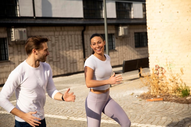 Guapo joven pareja fitness corriendo en zona urbana