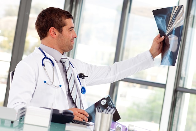 Guapo médico mirando una radiografía