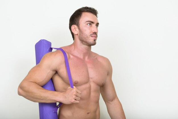 Guapo musculoso hombre persa barbudo sin camisa y listo para el gimnasio en blanco