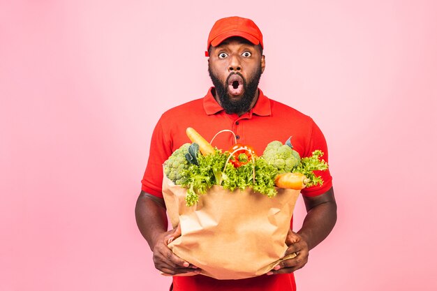 Guapo repartidor afroamericano que lleva la caja del paquete de comida de la tienda