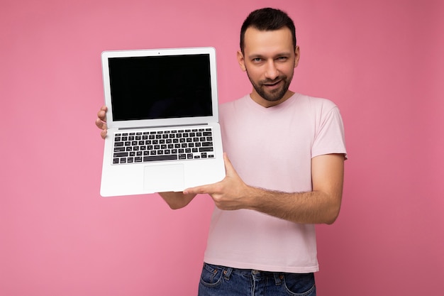 Guapo sonriente y guiñando un ojo brunet man holding laptop