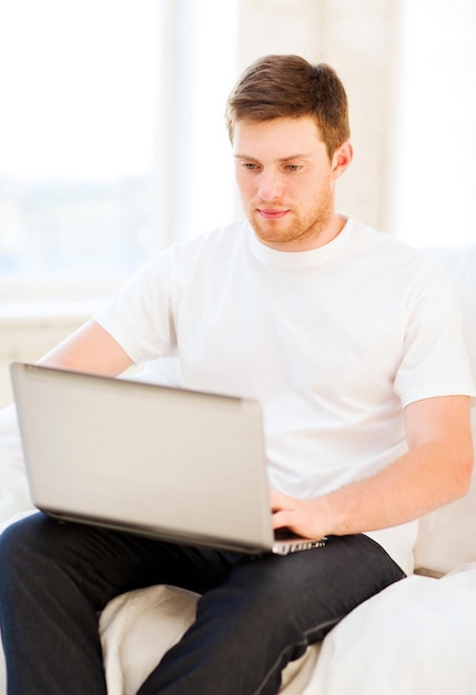 guapo, trabajando, con, computador portatil, en casa