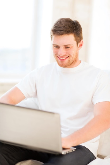 guapo, trabajando, con, computador portatil, en casa