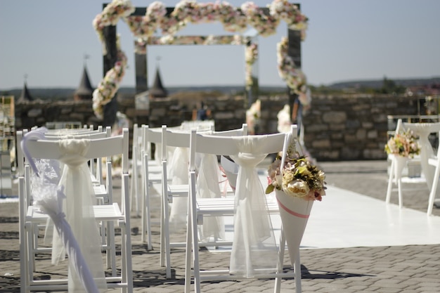 Guarda-chuva branco nas costas de uma cadeira em cerimônia de casamento, foco seletivo