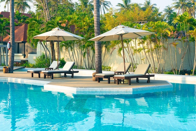 guarda-chuva com piscina ao redor da piscina com fundo do mar oceano - conceito de férias e férias