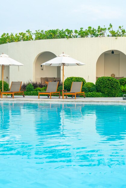 guarda-chuva com piscina ao redor da piscina com fundo do mar oceano - conceito de férias e férias