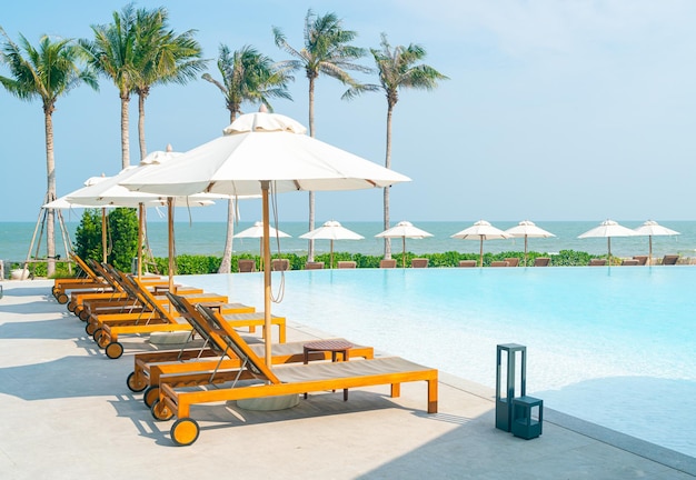 Guarda-chuva com piscina de cama ao redor da piscina com conceito de férias e férias de fundo do mar oceano