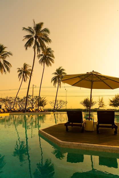 guarda-chuva com piscina de cama ao redor da piscina com fundo do mar oceano - conceito de férias e férias
