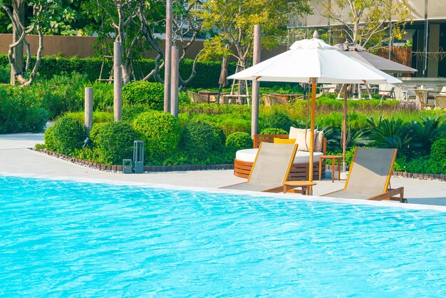 Foto guarda-chuva com piscina de cama ao redor da piscina com fundo do mar oceano