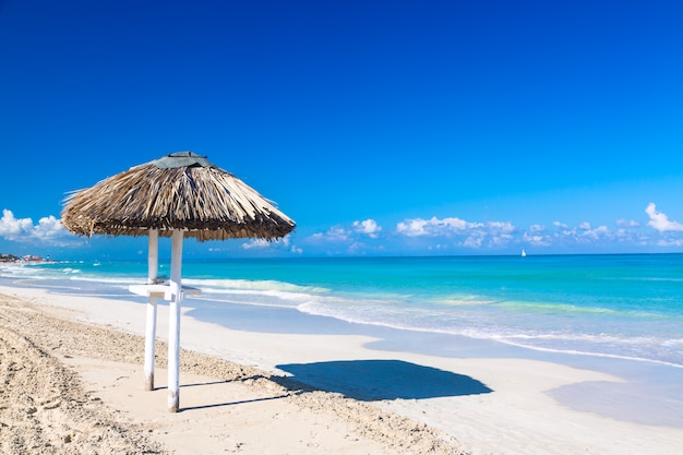 Guarda-chuva de palha na praia vazia à beira-mar em cuba