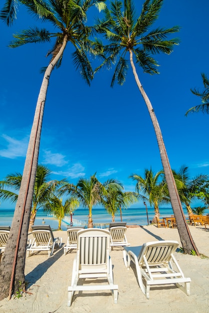 Foto guarda-chuva e cadeira em torno da praia e do mar para viagens e férias