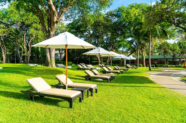 Guarda-chuva e cadeira no jardim para tomar sol ou relaxar