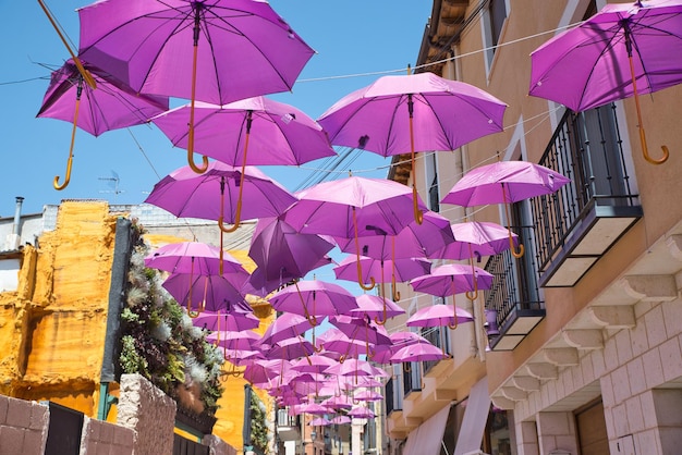 Guarda-chuvas cor-de-rosa sobre a cidade. Guarda-chuvas no céu, vista colorida. Apoio ao câncer de mama.