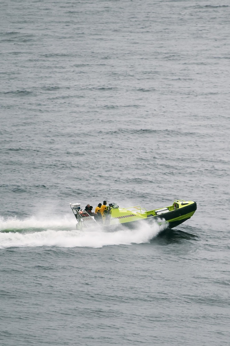 Foto guarda costeira a navegar rapidamente em mar agitado com um barco de resgate