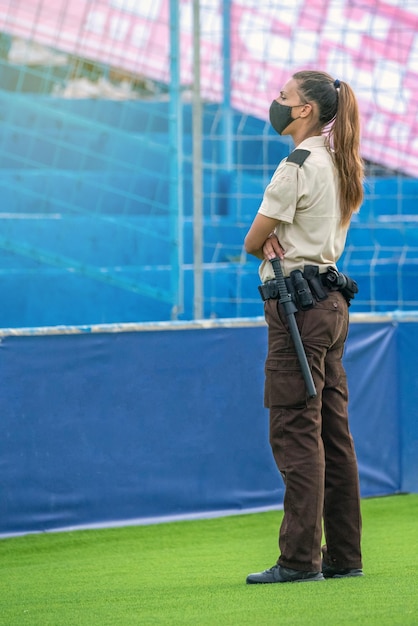 Foto guarda de segurança feminina pesquisando visualmente em um evento ao ar livre