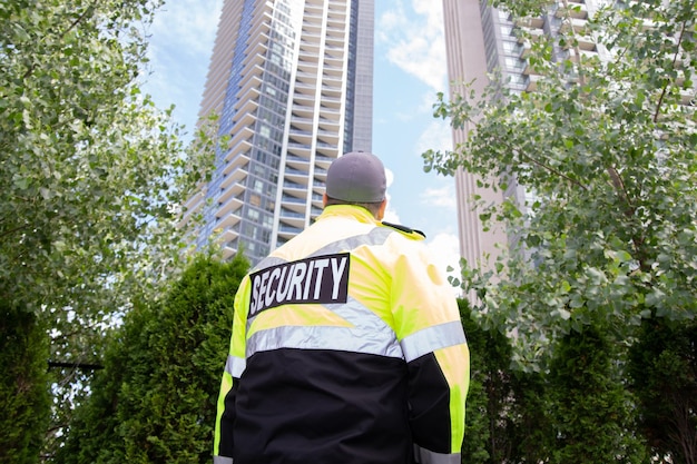 Foto guarda de segurança uniformizado patrulhando uma área residencial.