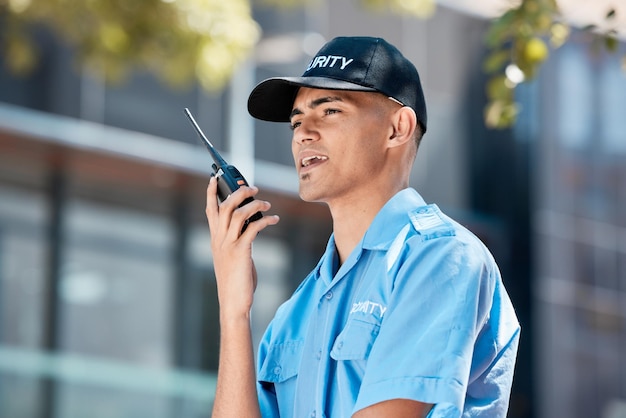 Guarda de segurança walkie talkie e homem na cidade em discussão de comunicação e conversa Proteção de segurança e oficial no rádio para conversar sobre tecnologia no serviço de aplicação da lei policial em área urbana ao ar livre