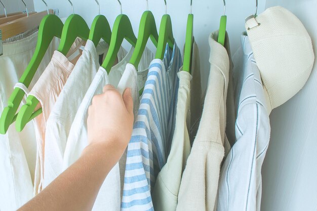 Guarda-roupa de verão com roupas de linho em cabides verdes