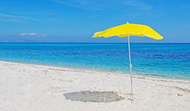 Guarda-sol amarelo em uma praia deserta