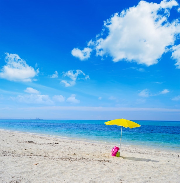 Guarda-sol e bolsa em uma praia tropical