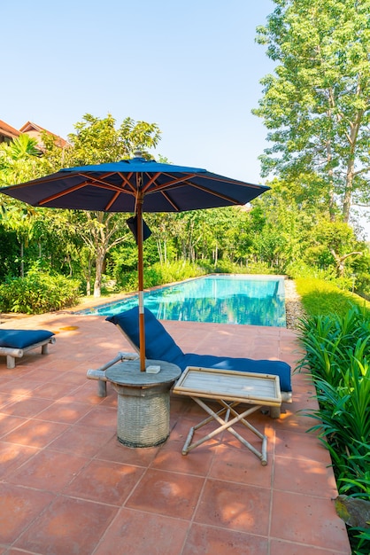 guarda-sol e cama ao redor da piscina com vista para o rio