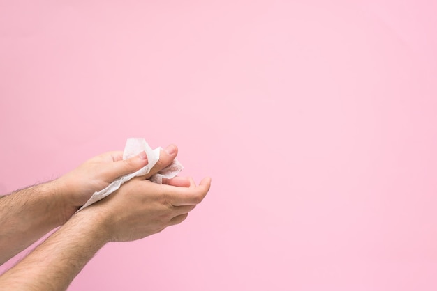 Guardanapo antimicrobiano para desinfecção das mãos durante uma pandemia de coronavírus. sobre um fundo rosa. espaço para texto.