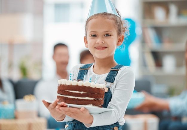 Guárdate un trozo. Retrato de una niña adorable celebrando un cumpleaños con su familia en casa.