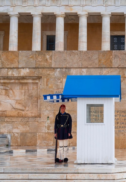 Guardia de la Guardia Evzon griega en la tumba del Soldado Desconocido en la Plaza Syntagma en Atenas bajo la lluvia