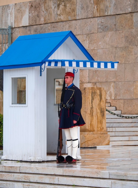 Guardia de la Guardia Evzon griega en la tumba del Soldado Desconocido en la Plaza Syntagma en Atenas bajo la lluvia