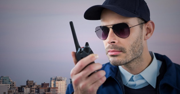 Guardia de seguridad con walkie talkie contra el horizonte y el cielo púrpura