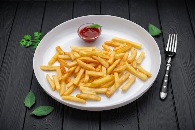 Guarnición apetitosa papas fritas con ketchup en un plato blanco