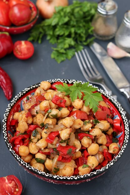 Guarnición de garbanzos con pimiento y tomate, un plato vegetariano rico en proteínas.