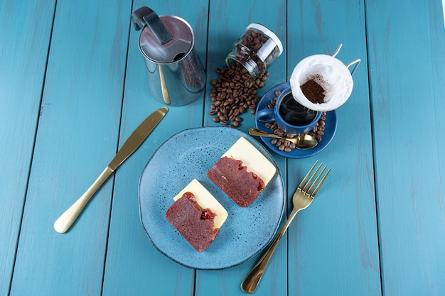 Guava süß mit Käse, umgeben von Besteckbecher und Kaffeebohnen auf einer blauen Tischplatte