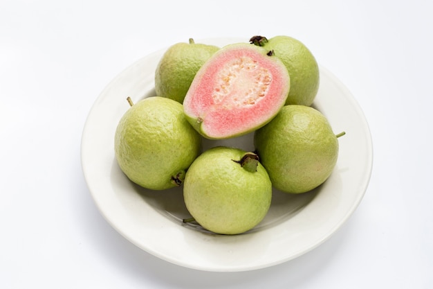 Guayaba fresca rosa sobre fondo blanco.