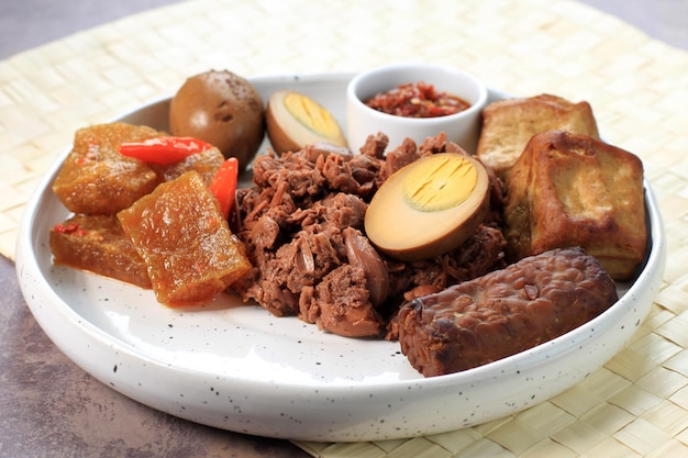 Gudeg. Un plato emblemático y legendario de Yogyakarta Indonesia. Guiso de Fruta de Jack Acompañado de Guiso Picante de Galletas de Piel de Ganado y Huevos Marrones, Tofu, Tempeh y Sambal.