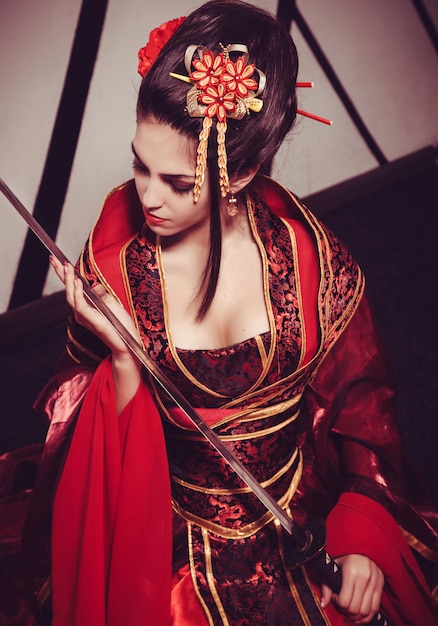 Gueixa bonita jovem no quimono com sakura e decoração