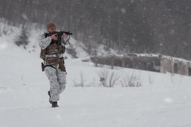 Guerra de invierno en la operación de las montañas árticas en condiciones frías soldado en uniforme camuflado de invierno