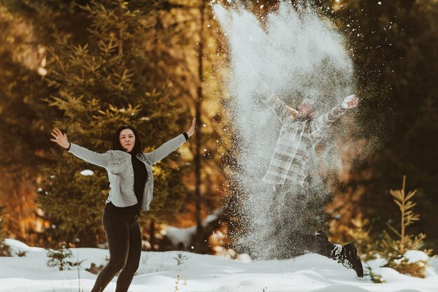 Guerra de nieve. Pareja de invierno divirtiéndose jugando en la nieve al aire libre. Jóvenes amantes felices y alegres. Enfoque selectivo. foto de alta calidad